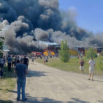 
              People watch as smoke bellows after a Russian missile strike hit a crowded shopping mall, in Kremenchuk, Ukraine, Monday, June 27, 2022. Ukrainian officials say scores of civilians are feared killed or injured after a Russian missile strike hit a crowded shopping mall in the central city of Kremenchuk. Ukrainian President Volodymyr Zelenskyy said in a Telegram post Monday that the number of victims was “unimaginable,” citing reports that more than 1,000 civilians were inside at the time of the attack. (Viacheslav Priadko via AP)
            