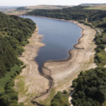 
              Low water levels are seen at Scammonden Reservoir in West Yorkshire as reservoir levels dip dangerously low amid record high temperatures in the UK. The UK's first ever red warning for exceptional heat came into force at midnight on Sunday, with temperatures expected to climb up to 41C (105.8F) over the next two days, breaking the country's heat records, Oldham, England, Monday, July 18, 2022. (AP Photo/Jon Super)
            