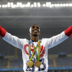 
              FILE Britain's Mo Farah celebrates winning the gold medal, in the men's 5000-meter medals ceremony, during the athletics competitions of the 2016 Summer Olympics at the Olympic stadium in Rio de Janeiro, Brazil, Saturday, Aug. 20, 2016. Four-time Olympic champion Mo Farah has disclosed he was brought into Britain illegally from Djibouti under the name of another child. The British athlete made the revelation in a BBC documentary. (AP Photo/Jae C. Hong, File)
            