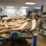 
              Stockpiles of wood lay destroyed from the floodwaters of Troublesome Creek at the Applachian School of Luthery workshop and museum in Hindman, Ky., Sunday, July 31, 2022. (AP Photo/Timothy D. Easley)
            