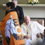 
              Pope Francis looks at a woman wearing a flag with the slogan Every Child Matters" on it at the end of a meeting with Indigenous people in Quebec City on Friday, July 29, 2022, part of his papal visit across Canada  (Jacques Boissinot/The Canadian Press via AP)
            