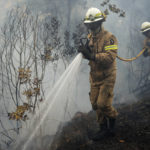 
              National Republican Guard firefighters put out a forest fire in the village of Rebolo, near Ansiao central Portugal, Thursday, July 14, 2022. Thousands of firefighters in Portugal have been battling fires all over the country that forced the evacuation of dozens of people from their homes. (AP Photo/Armando Franca)
            