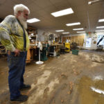 
              Paul Williams, luthery instructor at the Applachian School of Luthery inspects the damage at the workshop and museum in Hindman, Ky., Sunday, July 31, 2022. (AP Photo/Timothy D. Easley)
            