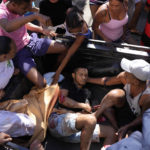 
              Residents place a wounded man in the back of a truck after a police operation that resulted in multiple deaths, in the Complexo do Alemao favela in Rio de Janeiro, Brazil, Thursday, July 21, 2022. Police said in a statement it was targeting a criminal group in Rio largest complex of favelas, or low-income communities, that stole vehicles, cargo and banks, as well as invaded nearby neighborhoods. (AP Photo/Silvia Izquierdo)
            