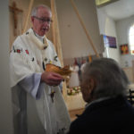 
              Edmonton Archbishop Richard Smith gives communion during the rededication ceremony and Sunday Mass at Sacred Heart Church of the First Peoples, July 17, 2022, in Edmonton, Alberta. In 2020, the church was damaged in a large fire and has now been renovated ahead of Pope Francis' visit to the Canadian province. (AP Photo/Jessie Wardarski)
            
