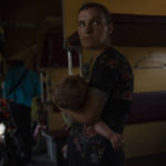 
              Internally displaced from Sloviansk, 26-year old Nataliia Tkachenko, holds her 8-month old son Oleksii, on a train leaving to Dnipro, in the Pokrovsk train station, Donetsk region, eastern Ukraine, Wednesday, July 6, 2022. Many are responding to the authorities' pleas to evacuate. As Russian troops march west, a steady flow of people continue to evacuate from towns caught in the crosshairs of the war, with hundreds leaving on a daily evacuation train from Pokrovsk. (AP Photo/Nariman El-Mofty)
            