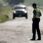 
              A Missouri state trooper controls traffic, Tuesday, June 28, 2022, on a road leading to the scene of an Amtrak train which derailed after striking a dump truck Monday near Mendon, Mo. (AP Photo/Charlie Riedel)
            