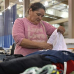 
              Evelyn Smith of Cary, Ky., gathers clothing at the Knott County Sportsplex in Leburn, Ky., Friday, July 29, 2022. Smith lost everything as fast rising floodwaters forced her from her home, and the sportsplex is being used as a evacuation center. (AP Photo/Timothy D. Easley)
            