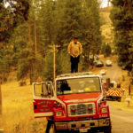 
              A firefighter stands atop a fire engine shortly after coming on duty to battle the Oak Fire in the Jerseydale community of Mariposa County, Calif., on Sunday, July 24, 2022. (AP Photo/Noah Berger)
            