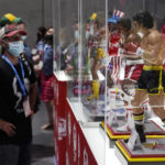 
              A Comic-Con attendee looks at small-scale statues of the movie characters Rocky Balboa and Apollo Creed from the "Rocky" film franchise, at the PCS Premium Collectibles Studio stall during Preview Night at the 2022 Comic-Con International at the San Diego Convention Center, Wednesday, July 20, 2022, in San Diego. (AP Photo/Chris Pizzello)
            