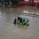 
              A rickshaw driver and a volunteer push a rickshaw stuck in a flooded road after a heavy rainfall in Karachi, Pakistan, Monday, July 11, 2022. The death toll from rain-related incidents over the past month has risen to 147 as monsoon rains continue to lash Pakistan, triggering flash floods in some parts of the country, officials said. (AP Photo/Fareed Khan)
            