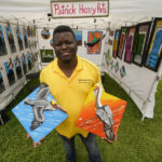 
              Local artist Patrick Henry shows some of his paintings of pelicans for sale at the Bayou Boogaloo festival in New Orleans, Saturday, May 21, 2022. The large coastal birds were among the first species declared endangered in the U.S. in 1970. Like bald eagles, their populations had been decimated by widespread DDT pesticide use, which thinned eggshells and prevented healthy chicks from hatching. (AP Photo/Gerald Herbert)
            