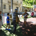 
              Miroslav, third from right, a refugee from the Ukraine, runs to embrace Rabbi Barbara Aiello, third from left, in the playground of Serrastretta, southern Italy, Friday, July 8, 2022. From a rustic, tiny synagogue she fashioned from her family's ancestral home in this mountain village, American rabbi Aiello is keeping a promise made to her Italian-born father: to reconnect people in this southern region of Calabria to their Jewish roots, links nearly severed five centuries ago when the Inquisition forced Jews to convert to Christianity. (AP Photo/Andrew Medichini)
            