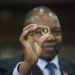 
              Reserve Bank of Zimbabwe Governor, John Mangudya holds a sample of a gold coin at the launch in Harare, Monday, July, 25, 2022.Zimbabwe has launched gold coins to be sold to the public in a bid to to tame runaway inflation that has further eroded the country's unstable currency. (AP Photo/Tsvangirayi Mukwazhi)
            