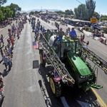 
              A tractor drives along Main Street during the Fourth of July parade Monday, July 4, 2022, in Delta, Utah. In this tiny Utah town surrounded by cattle, alfalfa fields and scrub-lined desert highways, hundreds of workers over the next few years will be laid off as the coal power plant closes— casualties of environmental regulations and competition from cheaper energy sources. (AP Photo/Rick Bowmer)
            