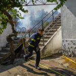 
              A firefighter works to extinguish a fire as wildfires get close to a house in Tabara, north-west Spain, Tuesday, July 19, 2022. (AP Photo/Bernat Armangue)
            