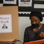 
              Barbara McLean uses a magnifying glass while going over her ballot before casting her vote at Edmondson Westside High School during Maryland's primary election, Tuesday, July 19, 2022, in Baltimore. (AP Photo/Julio Cortez)
            