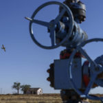 
              A crop dusting plane flies over a field next to an oil well in the Permian Basin in Lenorah, Texas, Friday, Oct. 15, 2021. Methane emissions are notoriously hard to track because they are intermittent. An old well may be wafting methane one day, but not the next. (AP Photo/David Goldman)
            