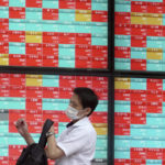 
              A man wearing a protective mask walks in front of an electronic stock board showing Japan's stock prices at a securities firm Friday, July 15, 2022, in Tokyo. Share prices were mixed in Asia on Friday after China reported its economy contracted by 2.6% in the last quarter as virus shutdowns kept businesses closed and people at home.(AP Photo/Eugene Hoshiko)
            