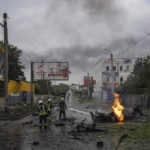 
              Rescue workers put out the fire of a destroyed car after a Russian attack in a residential neighborhood in downtown Kharkiv, Ukraine, on Monday, July 11, 2022. The top official in the Kharkiv region said Monday the Russian forces launched three missile strikes on the city targeting a school, a residential building and warehouse facilities. (AP Photo/Evgeniy Maloletka)
            