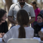 
              German Minister of Foreign Affairs Annalena Baerbock, speaks , left, with refugees at a refugee camp in the western Athens' suburb of Schisto, on Thursday, July 28, 2022. Baerbock is on a two-day official visit to Greece. (AP Photo/Petros Giannakouris)
            