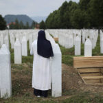 
              A woman prays near a grave of a family member in the Memorial centre in Potocari, Bosnia, Friday, July 8, 2022. After surviving the 1995 Srebrenica massacre in which over 8,000 of their male relatives were killed, women from the small town in eastern Bosnia dedicated the remaining years of their lives to the re-telling of their trauma to the World, honoring the victims and bringing those responsible for  the killings to justice. (AP Photo/Armin Durgut)
            