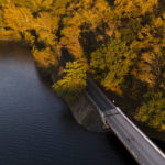 
              FILE - In this photo taken with a drone, cyclists, bottom right, cruise on a small bridge over the Loch Raven Reservoir, Oct. 27, 2021, in Glen Arm, Md. Federal regulations run through American life, touching on everything we consume, the air we breathe, the water we drink. (AP Photo/Julio Cortez, File)
            