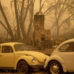 
              A chimney stands behind cars as the McKinney Fire burns in Klamath National Forest, Calif., on Sunday, July 31, 2022. (AP Photo/Noah Berger)
            