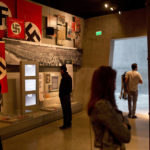 
              FILE - People look at an exhibit as they tour the Yad Vashem Holocaust Memorial Jerusalem, Sunday, April 23, 2017. U.S. President Joe Biden's dash through the Israel and the occupied West Bank this week is expected to cut across some of the region's most iconic places. Both luxurious and grueling, Biden's visit starts with a VIP arrival at Israel's main commercial airport and pings through Jerusalem and the occupied West Bank. In between his meetings with Israeli and Palestinian leaders, he will visit a host of well-known sites while staying at a historic Jerusalem hotel. (AP Photo/Oded Balilty, File)
            