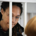 
              WNBA star and two-time Olympic gold medalist Brittney Griner speaks with her lawyers standing in a cage at a court room prior to a hearing, in Khimki just outside Moscow, Russia, Tuesday, July 26, 2022. American basketball star Brittney Griner has returned to a Russian courtroom for her drawn-out trial on drug charges that could bring her 10 years in prison if convicted. (AP Photo/Alexander Zemlianichenko, Pool)
            