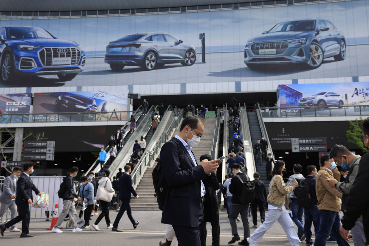 FILE - Visitors attend the Shanghai Auto Show in Shanghai on Wednesday, April 21, 2021. China’s a...