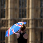 
              A mother shelters her baby from the sun with an umbrella on Westminster Bridge in London, Tuesday, July 19, 2022. Britain shattered its record for highest temperature ever registered amid a heat wave that has seized swaths of Europe. The national weather forecaster predicted it would get hotter still Tuesday in a country ill prepared for such extremes. (AP Photo/Frank Augstein)
            