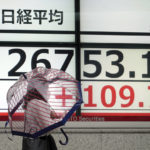 
              A person wearing a protective mask walks in front of an electronic stock board showing Japan's Nikkei 225 index at a securities firm Friday, July 15, 2022, in Tokyo. Share prices were mixed in Asia on Friday after China reported its economy contracted by 2.6% in the last quarter as virus shutdowns kept businesses closed and people at home. (AP Photo/Eugene Hoshiko)
            