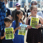 
              Children hold signs as backers of a proposed gun initiative deliver the signatures of thousands of voters on Friday, July 8, 2022, to state election offices in Salem, Ore. (AP Photo/Andrew Selsky)
            