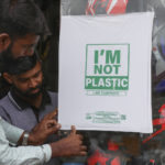 
              Workers of a helmet store paste degradable plastic substitute material on a glass in Hyderabad, India, Thursday, June 30, 2022. India banned some single-use or disposable plastic products Friday as a part of a longer federal plan to phase out the ubiquitous material in the nation of nearly 1.4 billion people. (AP Photo/Mahesh Kumar A.)
            