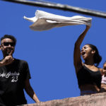 
              A resident waves a white sheet in protest after a police operation that resulted in multiple deaths, in the Complexo do Alemao favela in Rio de Janeiro, Brazil, Thursday, July 21, 2022. Police said in a statement it was targeting a criminal group in Rio largest complex of favelas, or low-income communities, that stole vehicles, cargo and banks, as well as invaded nearby neighborhoods. (AP Photo/Silvia Izquierdo)
            