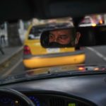 
              Ridery driver Marcelo Sanchez is reflected in the rear view mirror of his car in Caracas, Venezuela, Thursday, May 5, 2022. "I used to work as a private cab for a hotel, but it closed down. I've been working with Ridery for a month and it's not bad", says Sanchez. (AP Photo/Matias Delacroix)
            