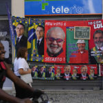 
              Towels featuring President Jair Bolsonaro, left, and former President Luiz Inacio da Silva, or Lula, hang for sale next to a chalkboard showing the vendor's daily sales count for each presidential contender towel, ahead of elections in Rio de Janeiro, Brazil, Wednesday, July 27, 2022. General elections are set for Oct. 2. (AP Photo/Silvia Izquierdo)
            