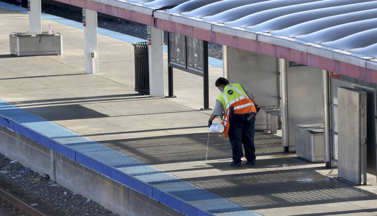 A CTA employee cleans up the platform of a closed off 63rd St. CTA Red Line station following an ea...