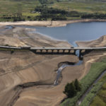 
              Traffic crosses a bridge at Woodhead Reservoir in West Yorkshire, England, Monday, July 18, 2022 as water levels dip dangerously low amid record high temperatures in the UK. Millions of people in Britain stayed home or sought shade Monday during the country's first-ever extreme heat warning, as hot, dry weather that has scorched mainland Europe for the past week moved north, disrupting travel, health care and schools. (AP Photo/Jon Super)
            