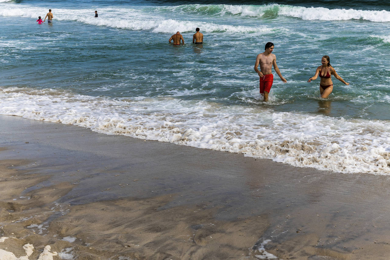 People swim in the ocean at Robert Moses State Park, Wednesday, July 27, 2022, in Babylon, N.Y. Sha...