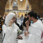 
              Muslim pilgrims chat as they leave the Grand Mosque, in Mecca, Saudi Arabia, Wednesday, July 6, 2022. Muslim pilgrims are converging on Saudi Arabia's holy city of Mecca for the largest hajj since the coronavirus pandemic severely curtailed access to one of Islam's five pillars. (AP Photo/Amr Nabil)
            