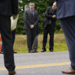 
              Volodymr Zhukovskyy, of West Springfield, Mass., center left, charged with negligent homicide in the deaths of seven motorcycle club members in a 2019 crash, is accompanied by defense attorney Steve Mirkin, center right, while visiting the site of the crash on a two-lane highway in Randolph, N.H., Monday, July 25, 2022. Zhukovskyy has pleaded not guilty to multiple counts of negligent homicide, manslaughter, reckless conduct and driving under the influence in the June 21, 2019, crash. Members of the jury visited the site for a viewing Monday. (AP Photo/Steven Senne, Pool)
            