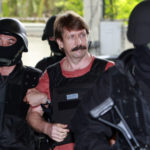 
              FILE - Viktor Bout, center, is led by armed Thai police commandoes as he arrives at the criminal court in Bangkok, Thailand, Tuesday, Oct. 5, 2010. The Russian arms dealer who once inspired a Hollywood movie is back in the headlines with speculation around a return to Moscow in a prisoner exchange for U.S. WBNA star Brittney Griner and former U.S. Marine Paul Whelan. (AP Photo/Apichart Weerawong, File)
            