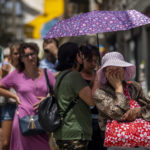 
              A woman queues to buy tickets of lottery during a hot and sunny day in Madrid, Spain, Monday, July 18, 2022. (AP Photo/Manu Fernandez)
            