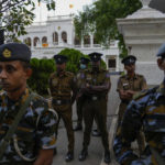 
              Army and police stand guard as protesters leave prime minister Ranil Wickremesinghe's office building in Colombo, Sri Lanka, Thursday, July 14, 2022. Sri Lankan protesters retreated from government buildings they seized and military troops reinforced security at the Parliament on Thursday, establishing a tenuous calm in a country in both economic meltdown and political limbo.(AP Photo/Rafiq Maqbool)
            