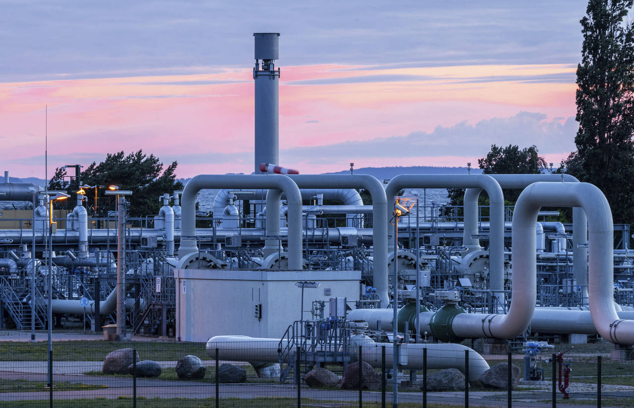 The sun rises behind the pipe systems and shut-off devices at the gas receiving station of the Nord...