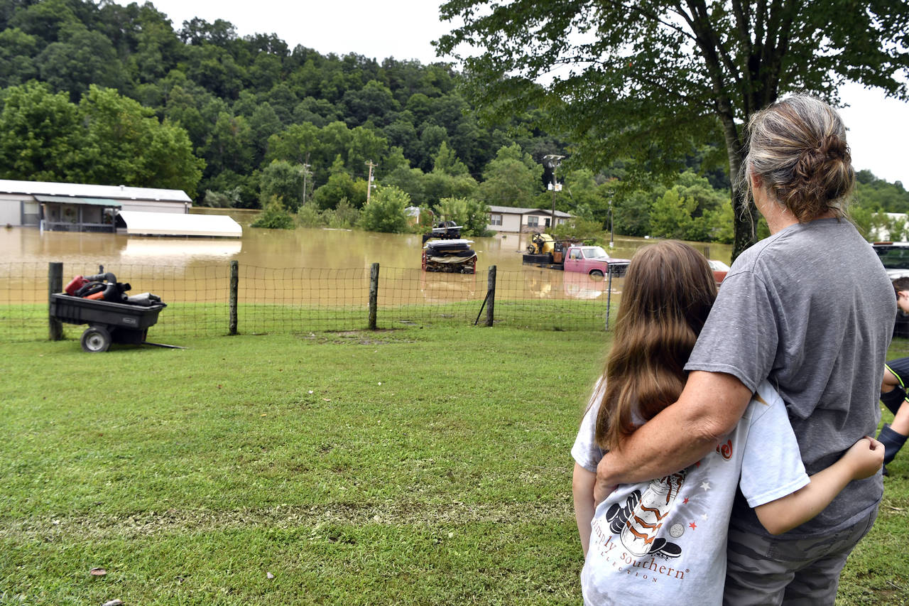 Bonnie Combs, right, hugs her 10-year-old granddaughter Adelynn Bowling watches as her property bec...