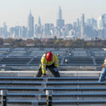
              FILE - Framed by the Manhattan skyline, electricians with IBEW Local 3 install solar panels on top of the Terminal B garage at LaGuardia Airport, Nov. 9, 2021, in the Queens borough of New York. The Supreme Court decision June 30, 2022, restricting the authority of the Environmental Protection Agency may mean continued pollution from power plants in states that are not switching to cleaner energy. But many states are switching and experts say they'll remain free to keep cleaning up their electrical grids under the new decision. (AP Photo/Mary Altaffer, File)
            