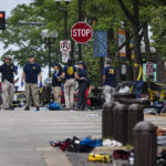 
              Members of the FBI's Evidence Response Team Unit investigate in downtown Highland Park, Ill., the day after a deadly mass shooting on Tuesday, July 5, 2022.   Police say the gunman who attacked an Independence Day parade in suburban Chicago fired more than 70 rounds with an AR-15-style gun.   (Ashlee Rezin /Chicago Sun-Times via AP)
            